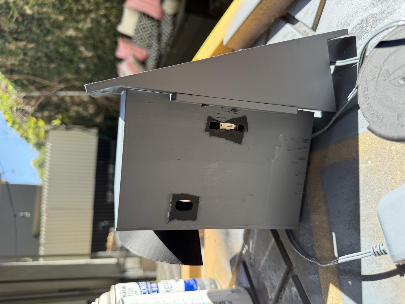 The sealed 3D-printed enclosure outdoors, side cooling fan and cable pass-through visible